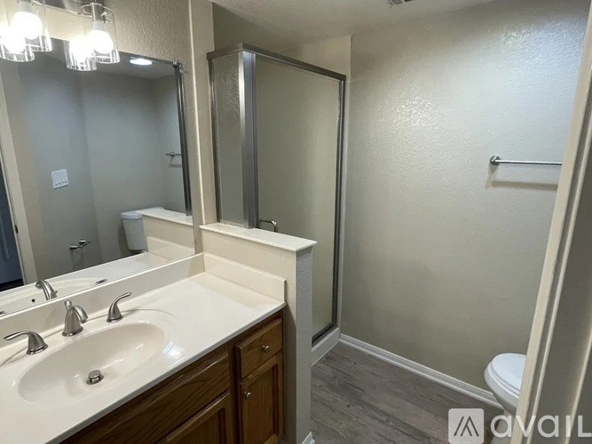 A bathroom with a sink, mirror, and toilet.