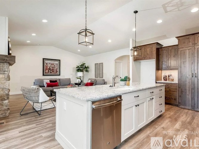 A kitchen with a white island and wooden floors.