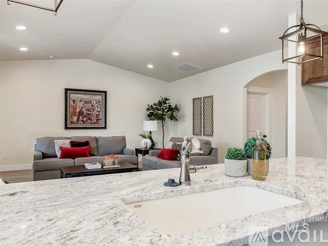 A modern living room with a grey sofa and a marble countertop.
