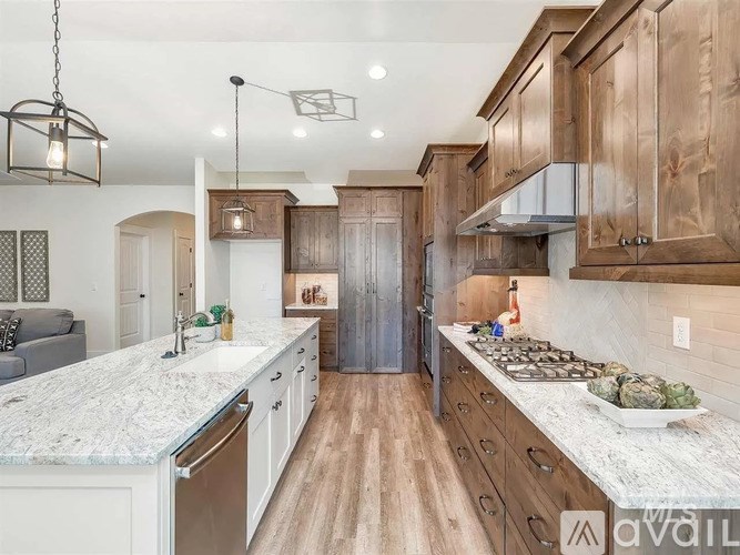 A kitchen with wooden cabinets and a marble countertop.