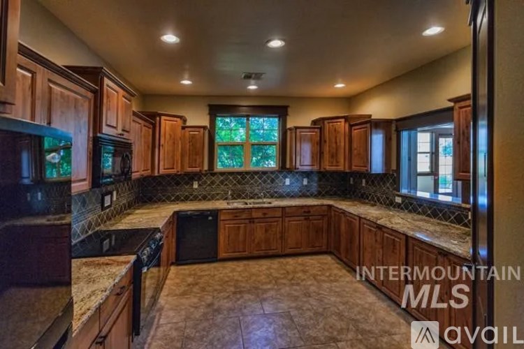 A kitchen with brown cabinets and a marble countertop.