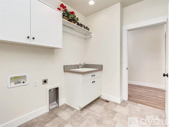 A kitchen with white cabinets and a sink.