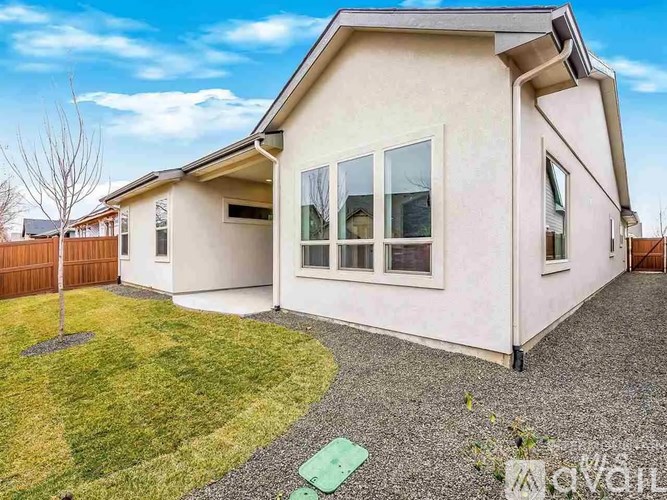 A house with a white exterior and a green lawn in front.