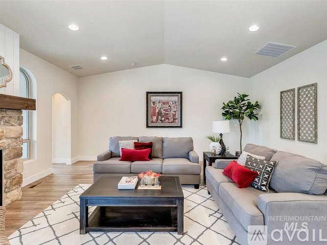 A living room with a grey couch, a coffee table, and a fireplace.