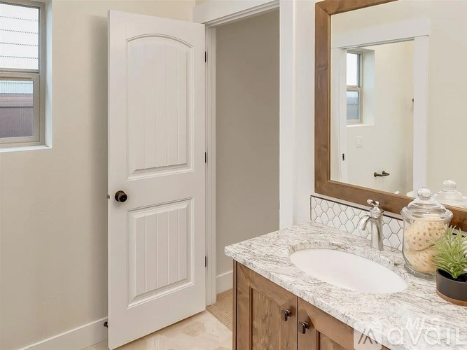A white door is open to a bathroom with a marble countertop.