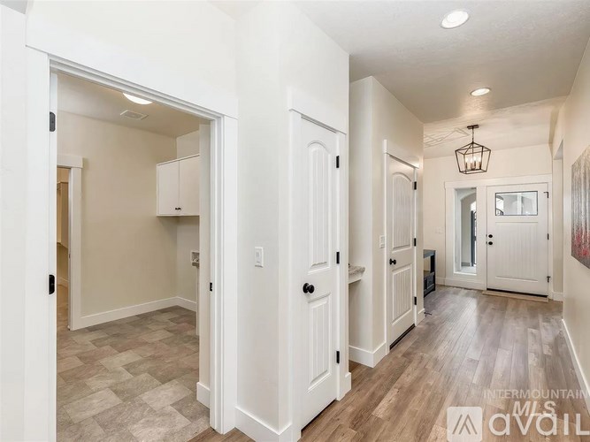 A hallway with white doors and wood floors.