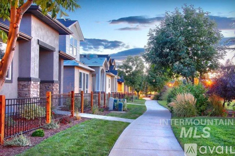 A residential street with houses on one side and a sidewalk on the other.