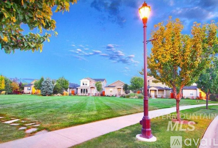 A street lamp stands on a sidewalk in front of a house.