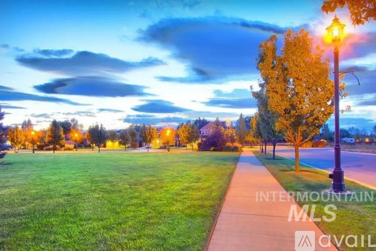 A sunset view of a park with a street light and trees.
