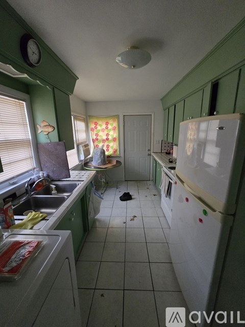 A kitchen with green walls and a white fridge.