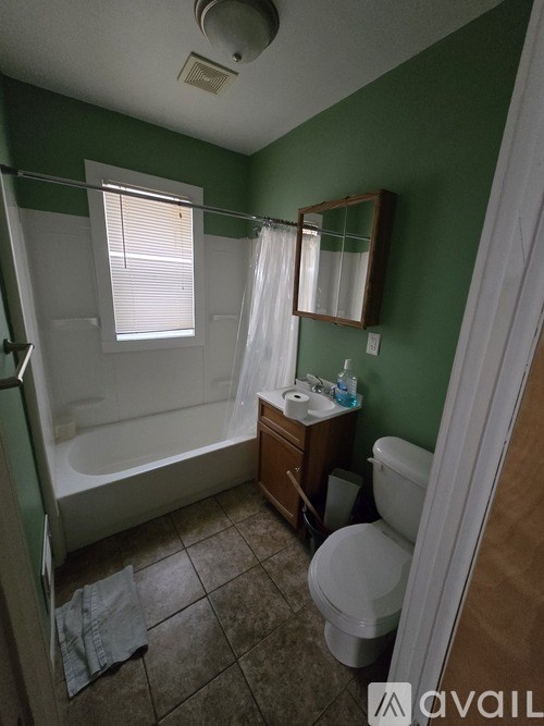 A bathroom with green walls and a white toilet.