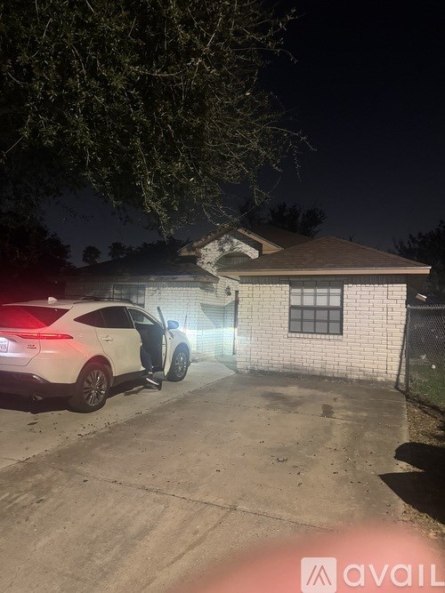 A car is parked in front of a house at night.