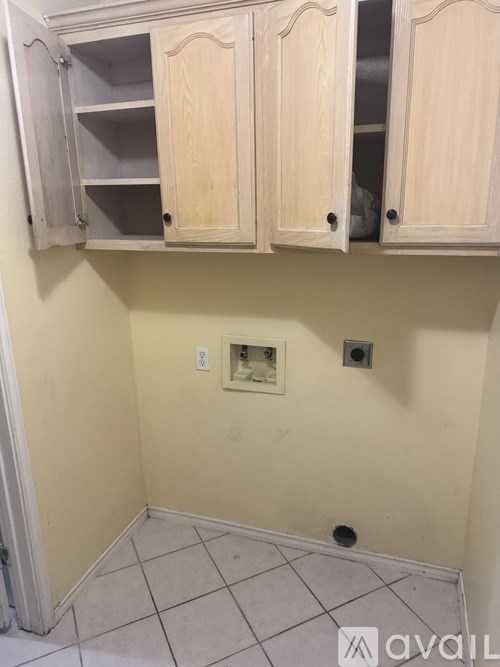 A kitchen with wooden cabinets and a tile floor.