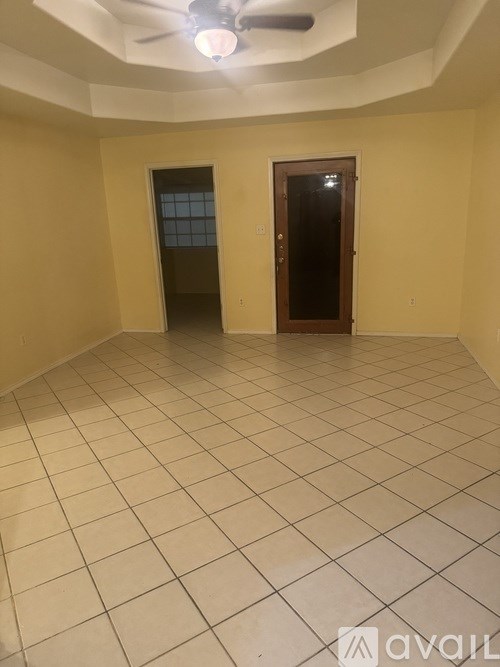 A room with a ceiling fan and two doors.