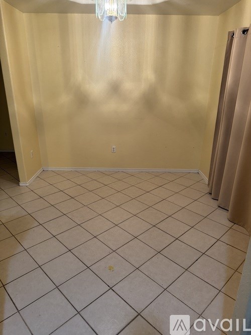 A room with a chandelier and a tiled floor.