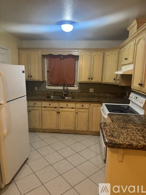 A kitchen with a white refrigerator and wooden cabinets.