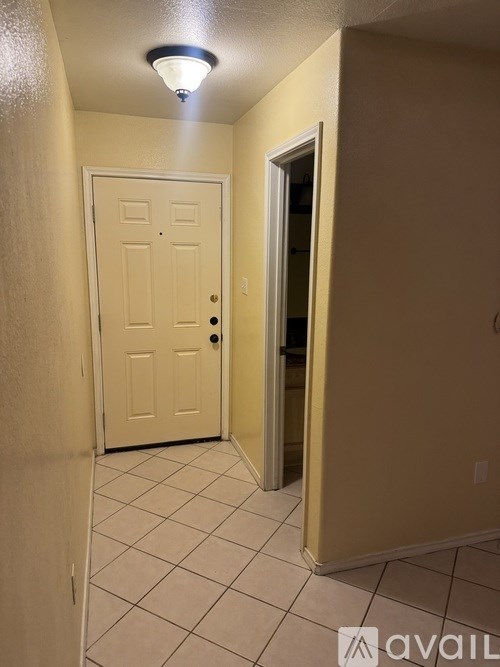 A hallway with a white door and a light on the ceiling.