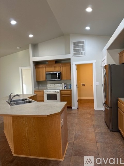 A kitchen with wooden cabinets and a large island.