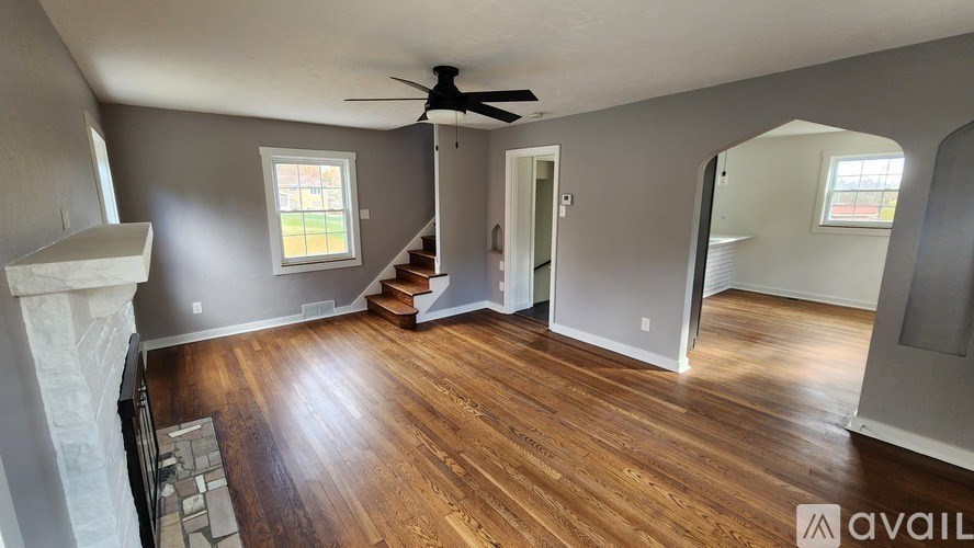 A room with a fireplace and wood flooring.