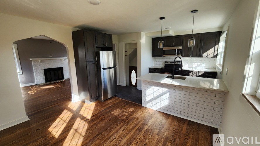 A kitchen with a white brick backsplash and wooden floors.