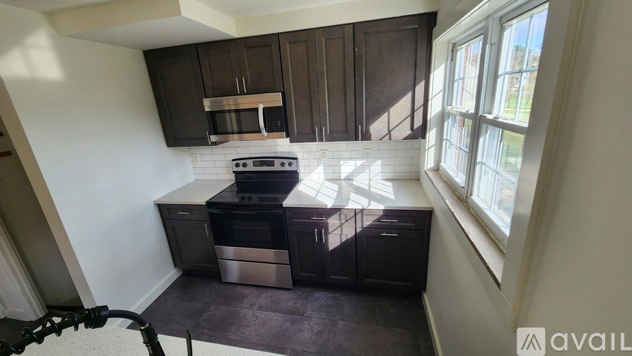 A kitchen with dark brown cabinets and a white backsplash.
