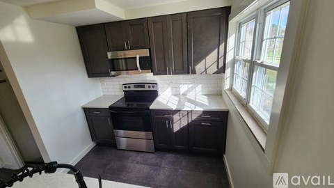 A kitchen with dark brown cabinets and a white backsplash.