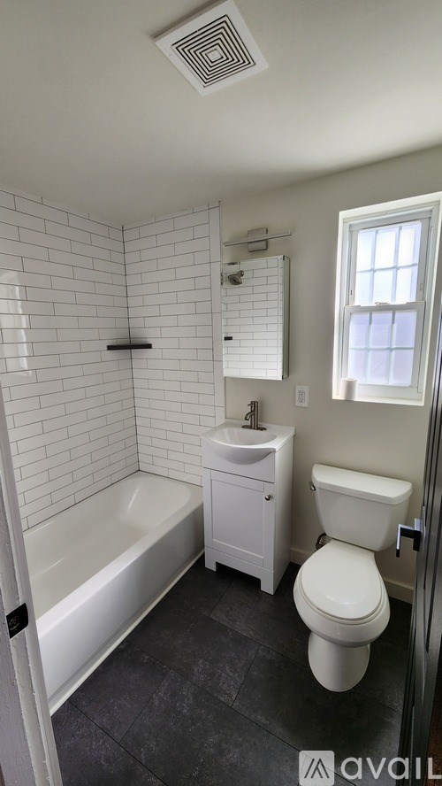 A white bathroom with a toilet, sink, and bathtub.