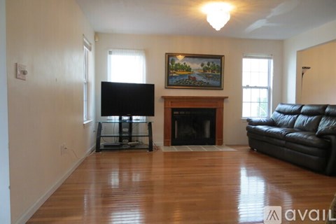 A living room with a fireplace and a painting on the wall.