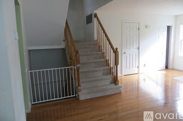 A staircase with a white railing leads to a door.