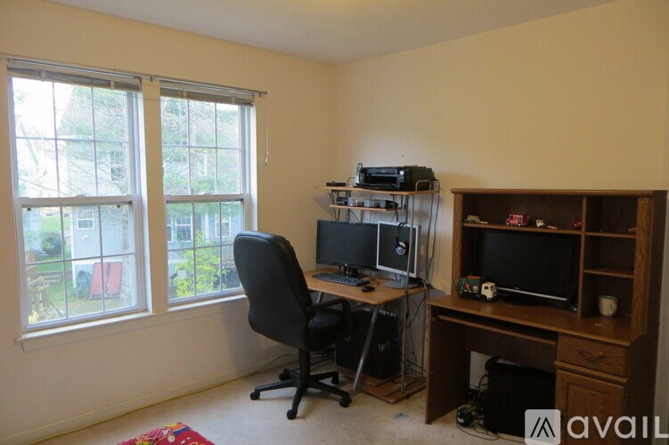 A room with a desk, chair, and computer setup.