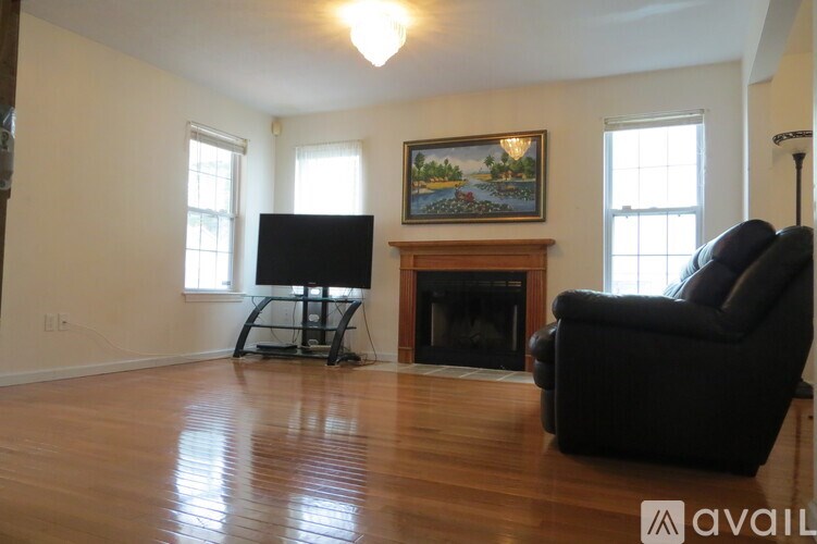 A living room with a fireplace and a painting on the wall.