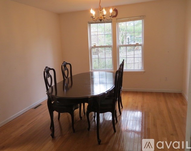 A dining room with a table and chairs.