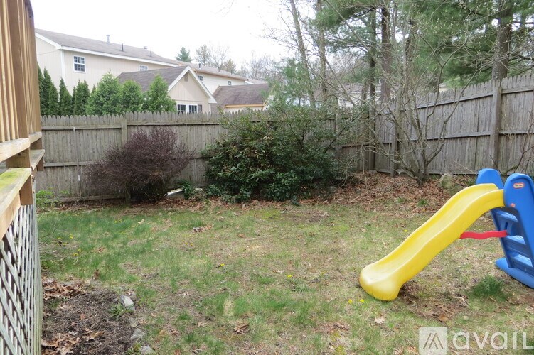 A blue and yellow slide in a backyard.