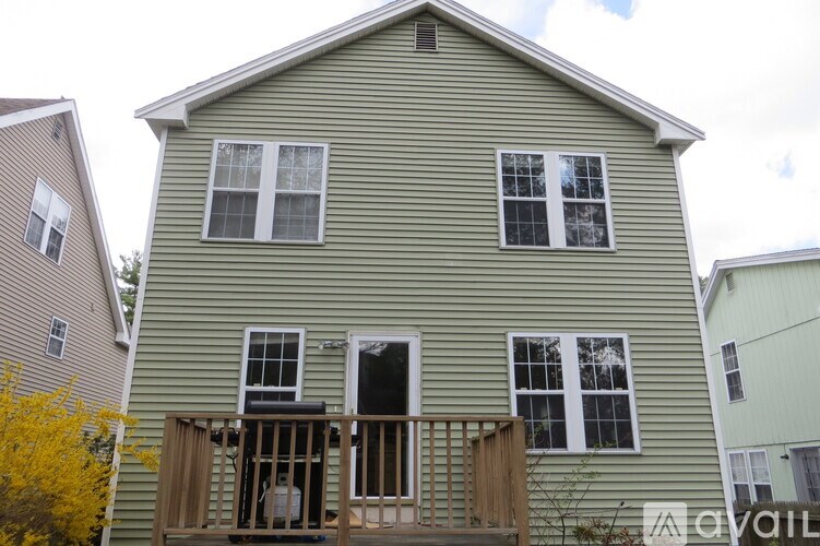 A house with a green siding and a balcony with a railing.