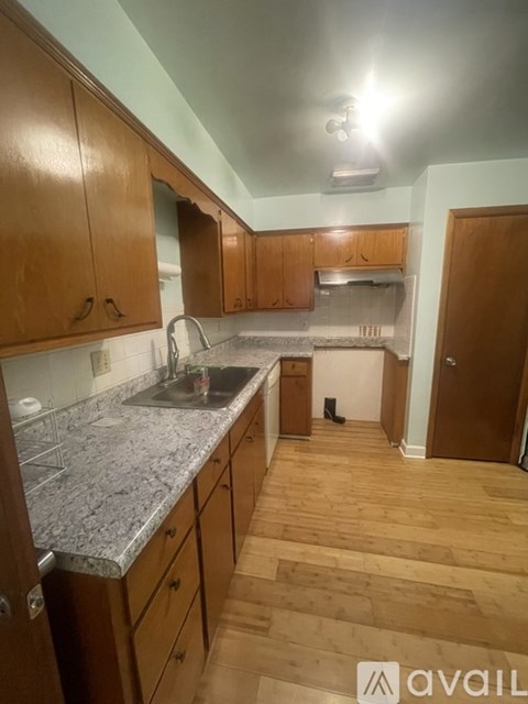 A kitchen with wooden cabinets and a granite countertop.