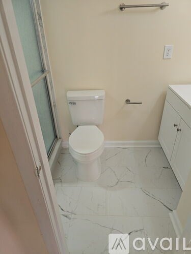 A white toilet in a bathroom with marble tiles.