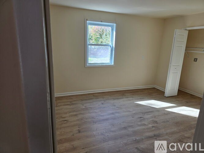 A room with wooden flooring and a window.