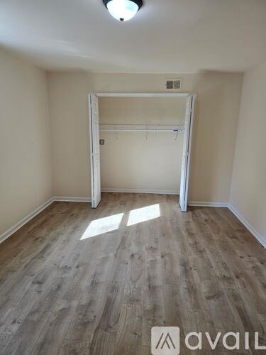 A room with a wooden floor and a white door.