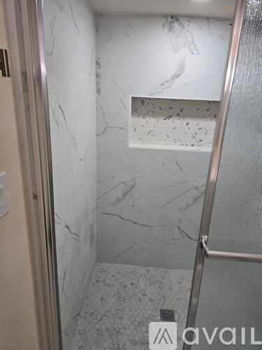 A bathroom with marble walls and floor.