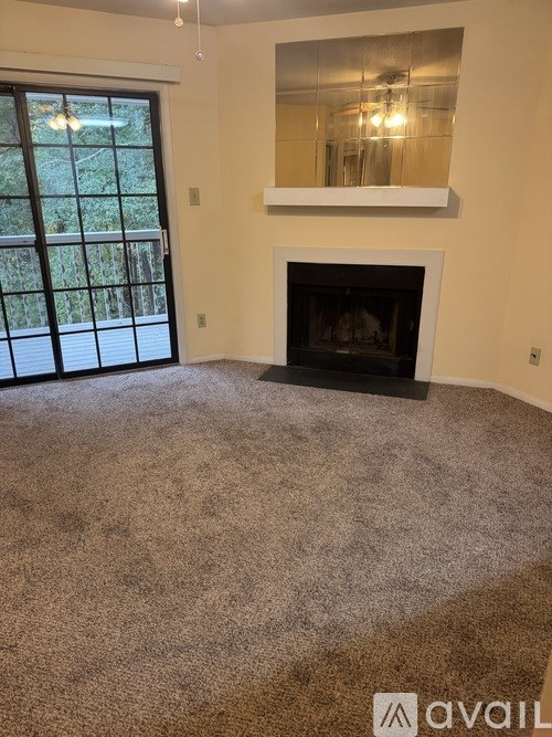 A living room with a fireplace and a large window.