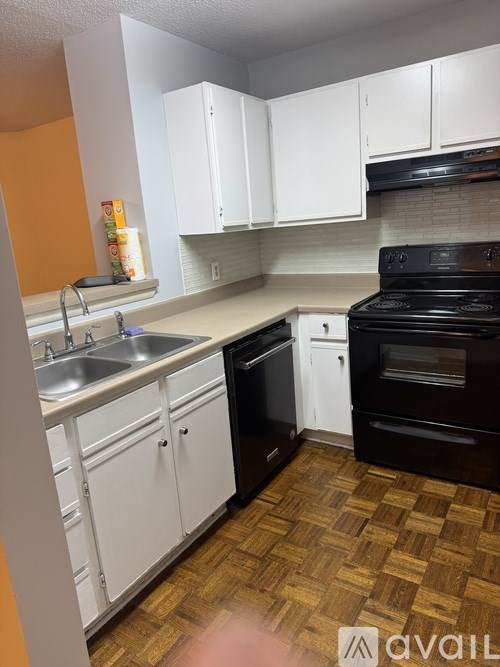A kitchen with white cabinets and a black stove top oven.