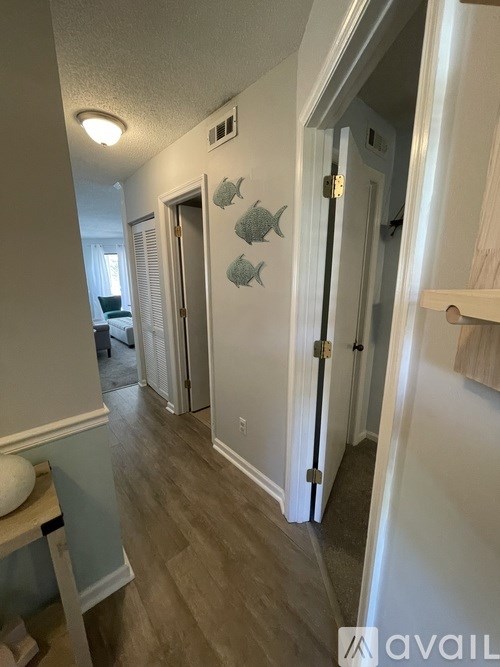 A hallway with a white door and a wall with fish decals.