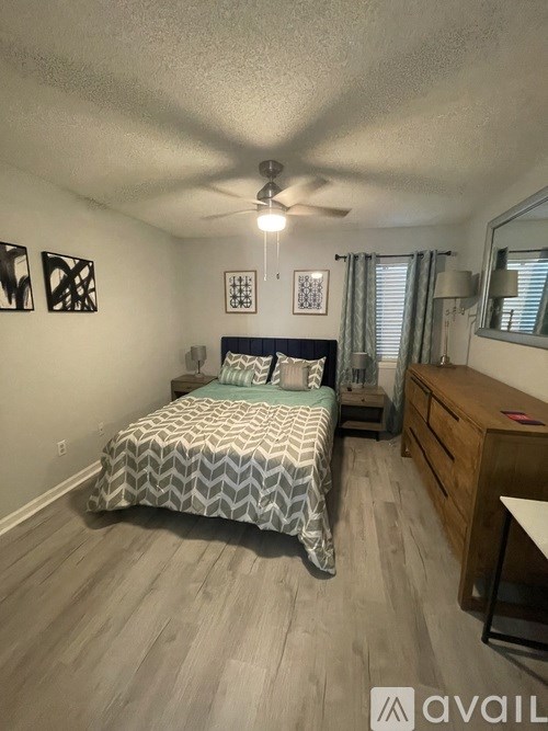 A bedroom with a bed, dresser, and mirror.
