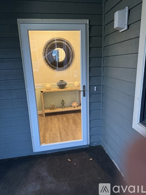 A white door with a mirror above it and a shelf below it.