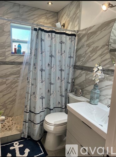 A bathroom with a toilet, sink, and shower curtain.