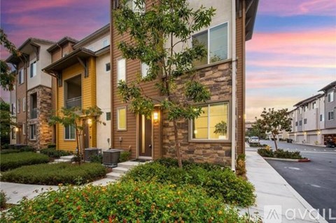 A modern two-story house with a front yard and landscaping.