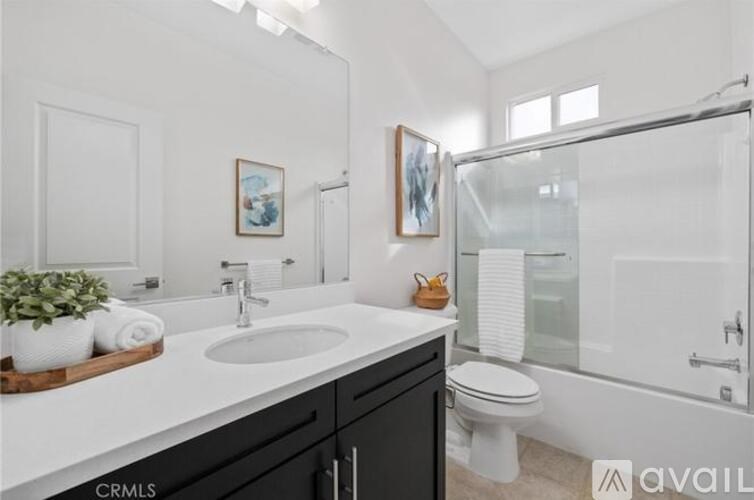 A bathroom with a white sink and black cabinets.