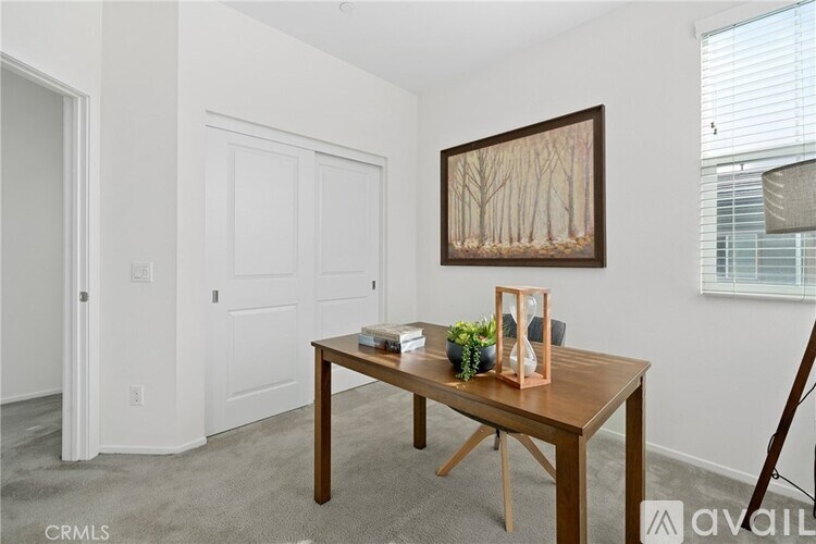 A room with a wooden table and a painting on the wall.
