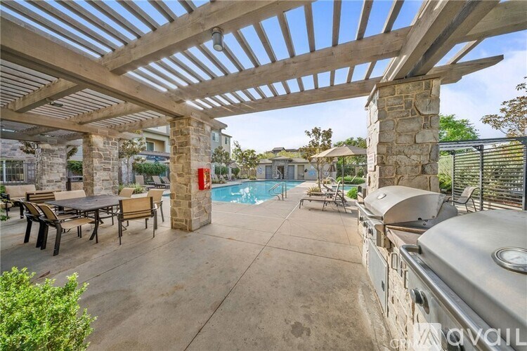 A patio with a table and chairs is covered by a wooden roof.