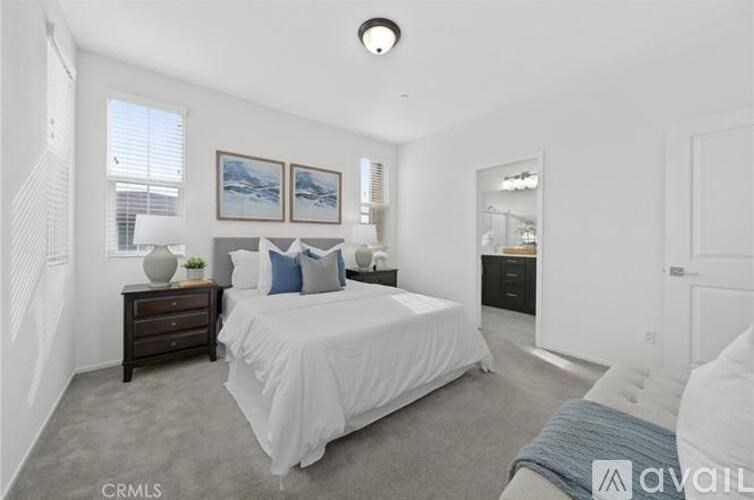 A bedroom with a bed, nightstand, and two framed pictures on the wall.